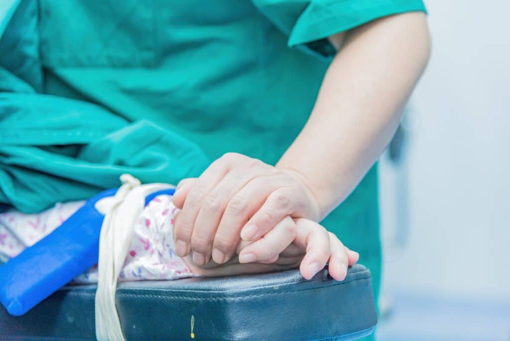 doctor holding hand of patient in operating room